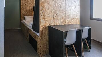 A compact room with a bed, a small table, and two chairs.