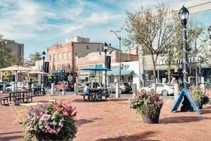 Explore the vibrant public square, surrounded by shops, seating areas, and a playground.