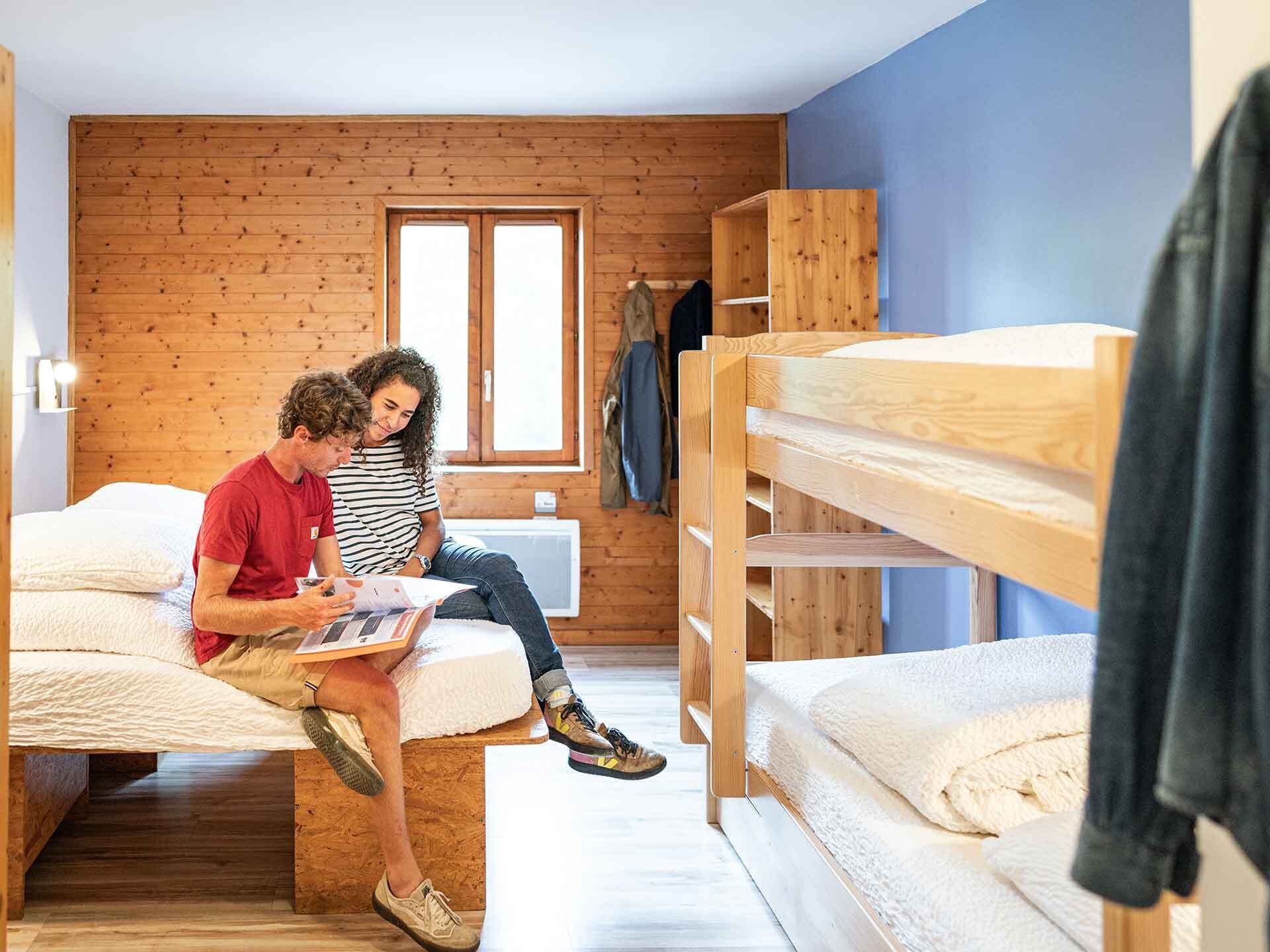 Un dormitorio con literas, una ventana y una pared de madera.