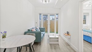 Una habitación moderna y luminosa con una mesa de comedor, un sofá y una pequeña mesa de centro.