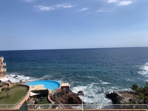 Et kysthotel med pool, havudsigt og klippeudsigte.