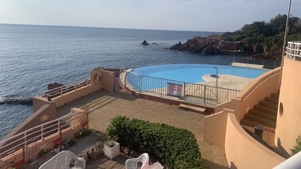 A pool area with a view of the sea, a staircase, and a small garden with plants. - Nice place with sea and swimming pool (Saint-Raphaël)