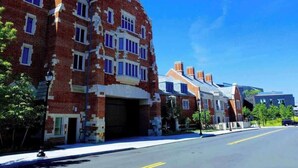 A row of brick buildings with uniform windows and a clear blue sky.