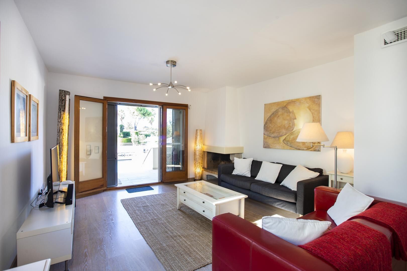 Un salon moderne avec un canapé, une table basse et un tableau accroché au mur.