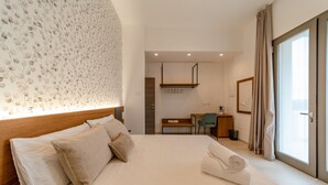 A hotel room with a large bed, a desk, and a view of the outdoors. - Sarmenti Agriresort (Otranto)