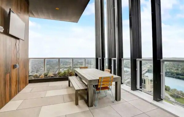 Enjoy meals at the central dining table, with a TV mounted nearby, and take in the city views from the balcony.