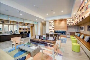 Cozy space with a variety of seating options, a large bookshelf, and a dining area.