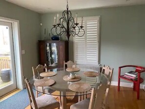 Enjoy meals in this cozy dining area with a round table and six chairs, a stylish chandelier, and a nearby cabinet for storage.