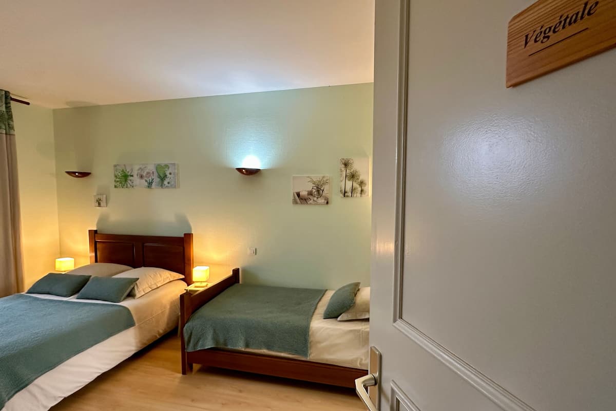 A bedroom with two beds, a wooden headboard, bedside lamps, and wall art.