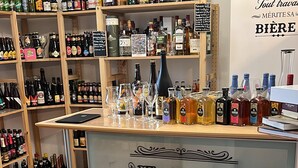 A bar with shelves of various liquor bottles and glasses. - La Maison Du Canal (Clamerey)