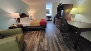 Une chambre d’hôtel équipée d’un lit, d’un bureau, d’une chaise et d’un petit coin cuisine.