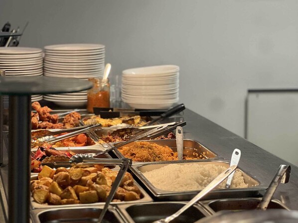 A buffet with various food items including fried chicken, rice, and vegetables.