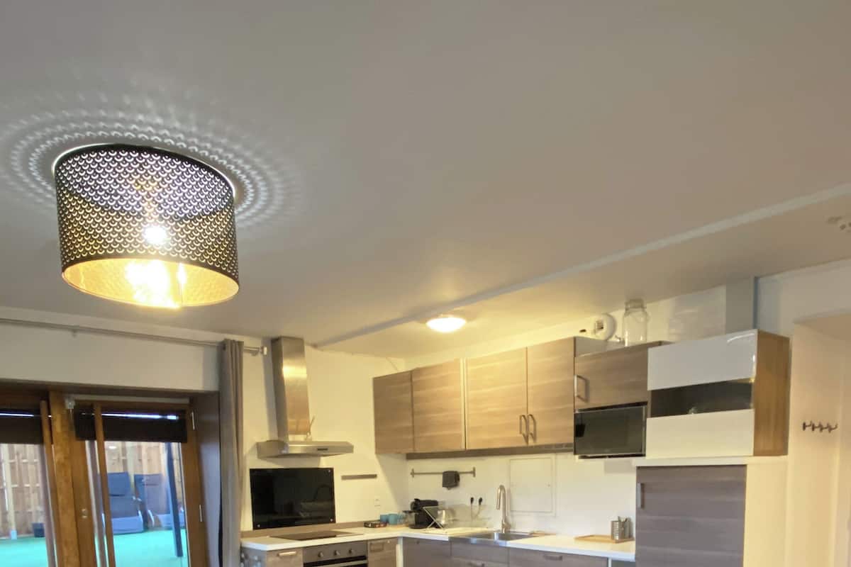 Una cocina moderna con comedor, que incluye una mesa, sillas, horno empotrado y microondas.