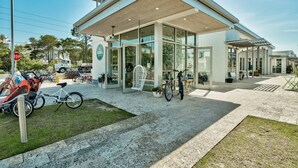 Un edificio moderno con fachada de vidrio, entrada cubierta y zona de aparcamiento para bicicletas.