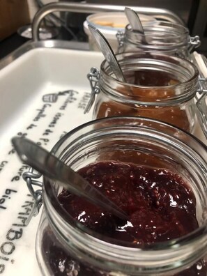 Tres frascos de vidrio con tapas metálicas y cucharas, sobre una bandeja blanca con texto impreso.