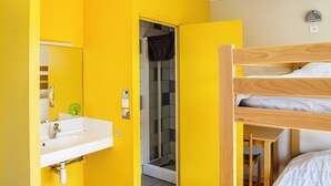 A room with a bunk bed, a sink, and a mirror.
