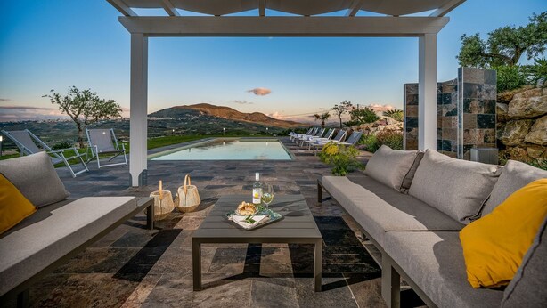 Una terraza con piscina, mobiliario exterior y vistas al paisaje.