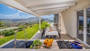 Un espacio de comedor al aire libre con vistas al campo y a las montañas.