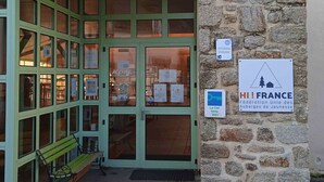 A building entrance with a green door, a stone wall, and a bench outside. - Auberge de Jeunesse HI Pontivy (Pontivy)