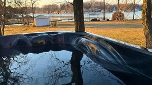 A swimming pool with a clear view of the surrounding area, including trees and a distant building. - Charming Lakefront Cottage (Vandalia)