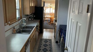 Una cocina compacta con armarios de madera, un lavamanos y un refrigerador.