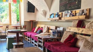 A rustic interior with a wooden bench seating area, a small table, and a chalkboard menu.