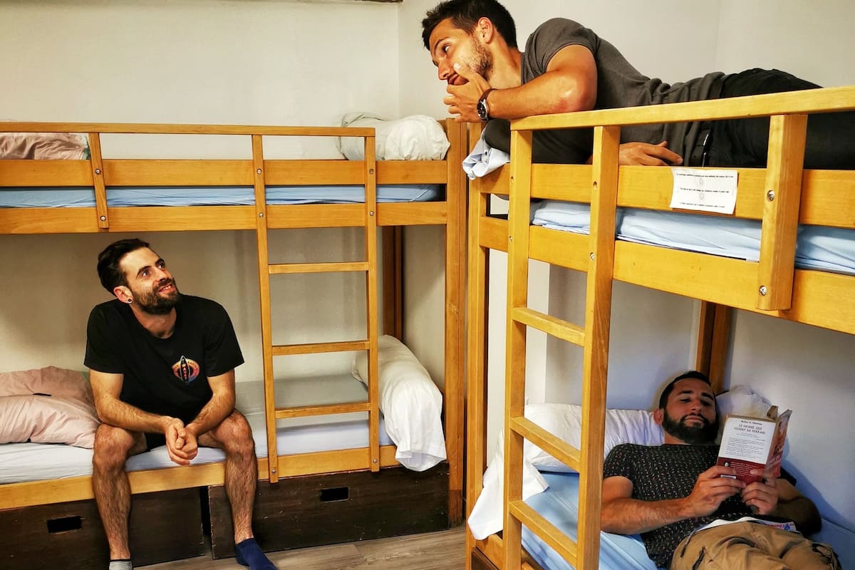Ein Schlafsaalzimmer mit Etagenbetten, Holzböden und einer schlichten Einrichtung.