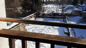 A balcony with a view of a snowy landscape and mountains.