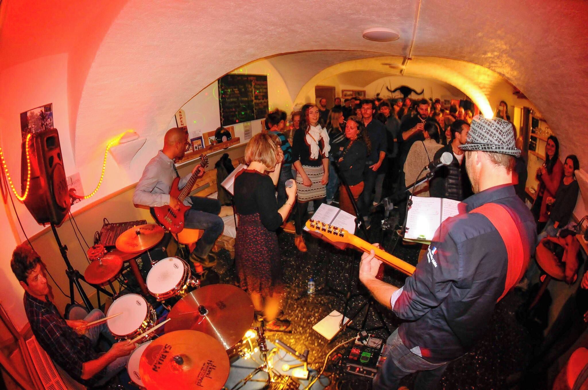 Una banda tocando en un salón lleno de gente.