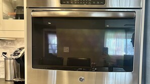 Horno GE doble con un reloj digital que marca las 3:30, integrado en los armarios de la cocina.