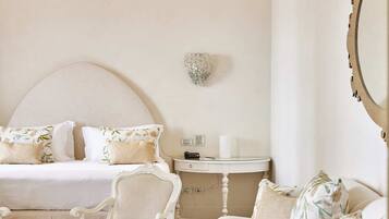 Quarto com cama, escrivaninha, cadeira e sofá.