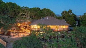 A house with a large deck, surrounded by trees and a vineyard. - Z Ranch - Modern French Country Style With Stunning Views (Atascadero)