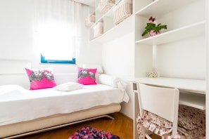Cozy retreat with a comfortable bed, desk, and chair, perfect for relaxing and working.