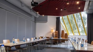 A conference room with long tables, chairs, and water bottles.