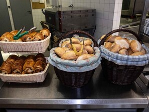 Three wicker baskets filled with various types of bread on a kitchen counter. - Auberge de Jeunesse HI Strasbourg (Strasbourg)