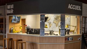 A mini bar and kitchenette area with a world map on the wall, a TV, and various kitchen appliances.
