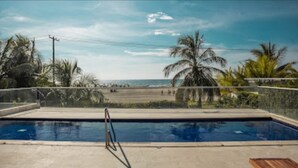 A swimming pool with a view of the beach and palm trees. - 1ME-6 APARTAMENTO FRENTE AL MAR CON WIFI (Cartagena)