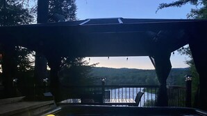 A hot tub area with a view of a lake and mountains. - Chalet with waterfront, Spa and magnificent view of a regional park (Chertsey)