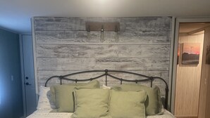 A bed with a metal frame and a headboard with a rustic design. - The Pink House - Charming, fully renovated, quiet getaway (Wellfleet)
