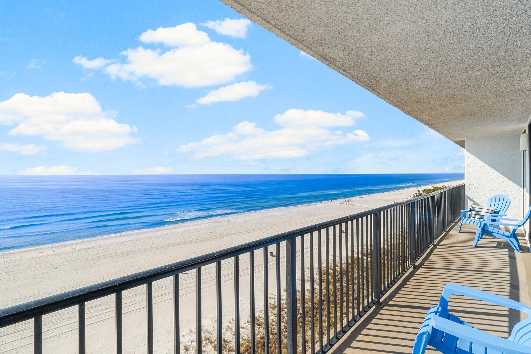 A balcony with a view of the beach and ocean.