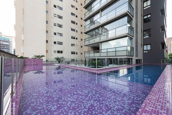 A modern building with a rooftop swimming pool.