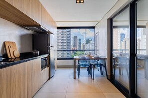 A modern kitchen with a large window overlooking a cityscape.