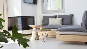 A modern living room with a sofa, a coffee table, and a television.