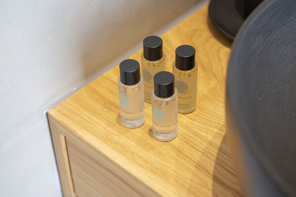 A wooden surface with four bottles of shampoo and body wash.