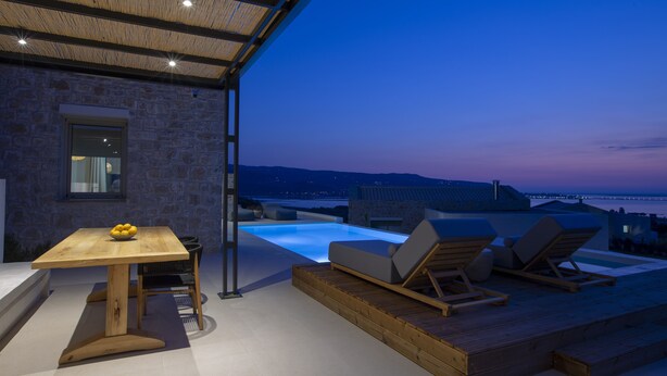 A rooftop terrace with a pool, lounge chairs, and a dining table.