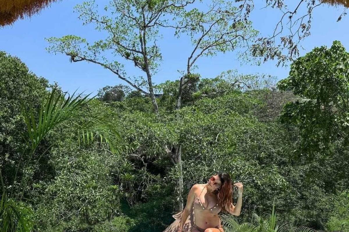 A person sitting in a pool surrounded by lush greenery.