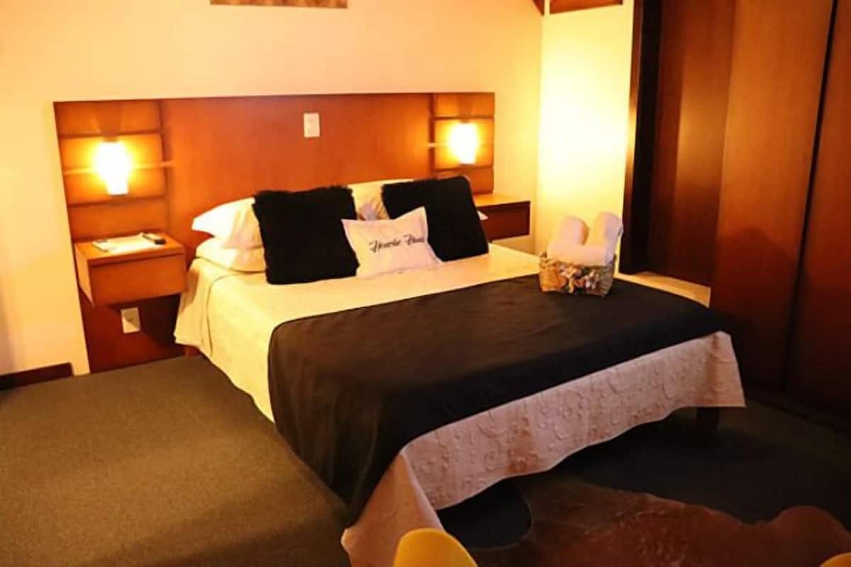 Ein Hotelzimmer mit Bett, Nachttischen und einem kleinen Tisch neben dem Bett.