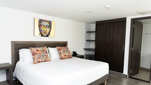 A modern bedroom with a large bed, two decorative pillows, a wall-mounted artwork, a bedside table, and a wardrobe. - Hotel Qatar Cali (Cali)
