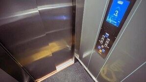 An elevator interior with a digital display showing the number 3, a logo on the floor, and a sign indicating 'edel' on the wall. - Hotel Qatar Cali (Cali)