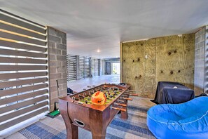 A modern room with a foosball table, a blue bean bag, and a large wooden wall.